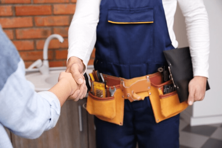 Plumber and woman shaking hands closeup